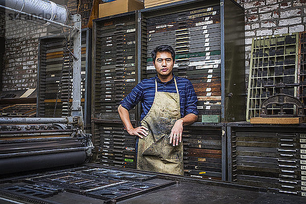 Porträt eines Arbeiters  der in der Werkstatt an Maschinen steht