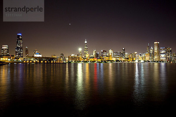Beleuchtete Stadtlandschaft am Lake Michigan bei Nacht gegen den Himmel