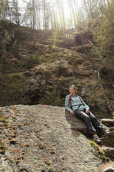 Wanderin entspannt sich am Fels