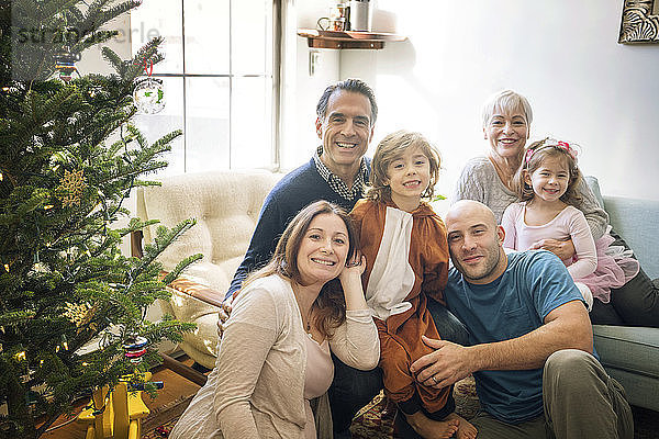 Porträt einer lächelnden Familie  die zu Hause Weihnachten feiert