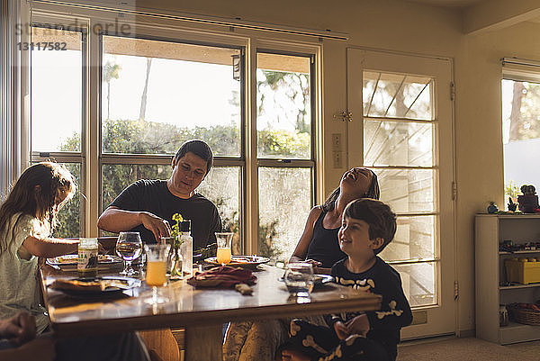 Glückliche Familie beim Frühstück am Esstisch