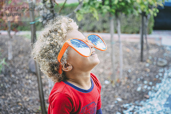 Verspielter Junge mit Sonnenbrille  der nach oben schaut