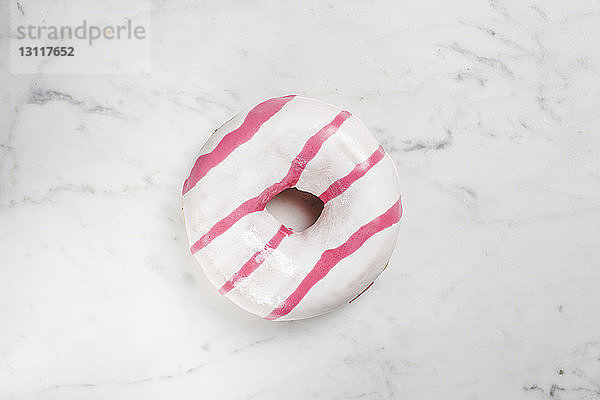 Draufsicht von Donut auf Marmortisch