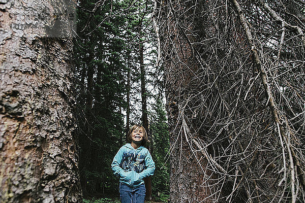 Fröhliches Mädchen steht im Wald