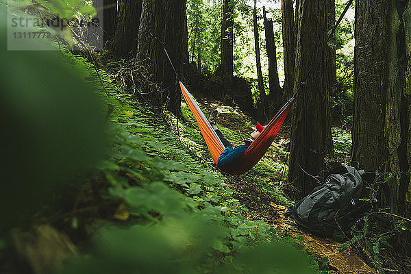 Frau entspannt sich auf Hängematte im Wald
