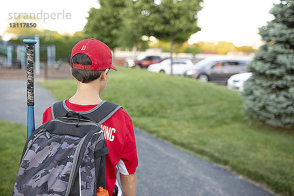 Rückansicht eines Baseball-Spielers mit Rucksack auf dem Spielfeld stehend