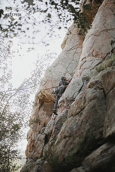 Tiefwinkelansicht eines Wanderers beim Bergsteigen gegen den Himmel