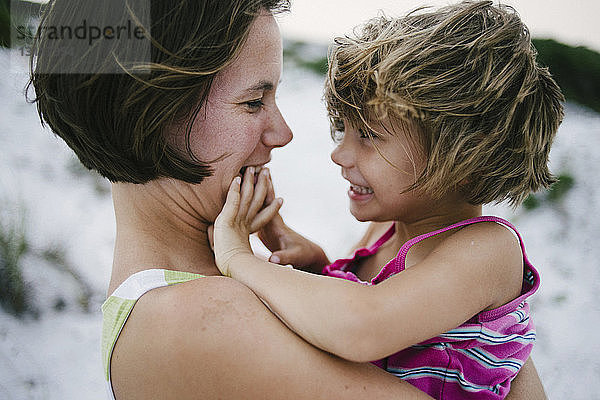 Seitenansicht einer Mutter mit glücklicher Tochter am Strand