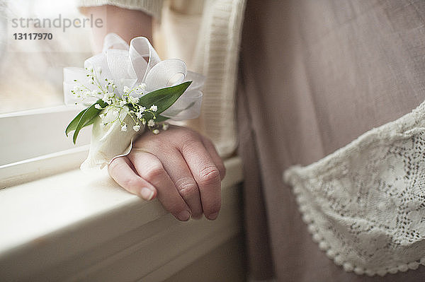 Mitschnitt eines Mädchens  das zu Hause Bänder und Blumenschmuck am Handgelenk trägt