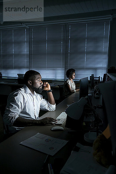 Mitarbeiter  die im Büro an Desktop-Computern arbeiten