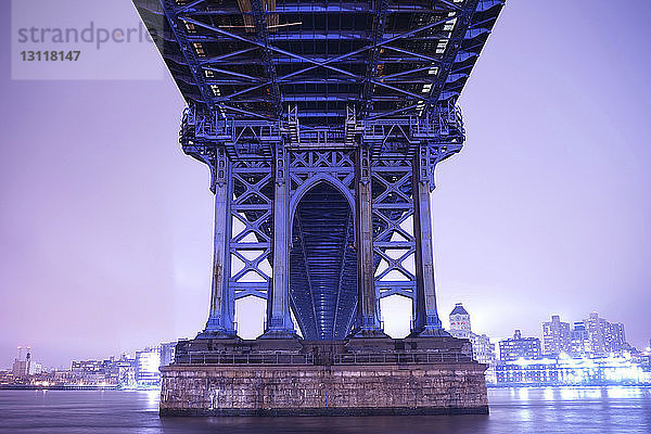 Niedrigwinkelansicht der Manhattan-Brücke über den East River bei beleuchteter Stadt