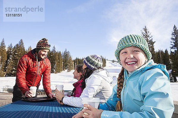 Mädchen schaut weg  während sie mit der Familie Kaffee trinkt