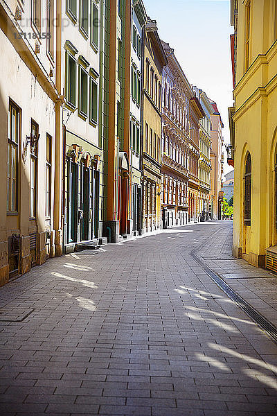 Schatten auf gepflasterter Straße inmitten von Gebäuden in der Stadt