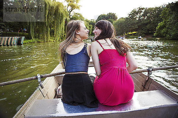 Rückansicht eines lesbischen Paares im Boot auf dem See
