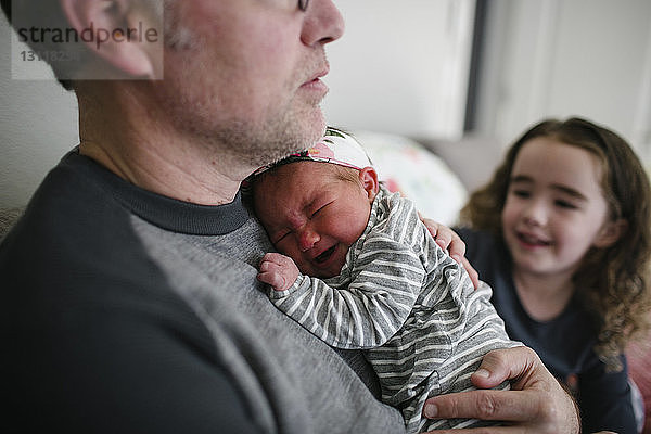 Vater tröstet weinendes Baby Mädchen für Tochter zu Hause