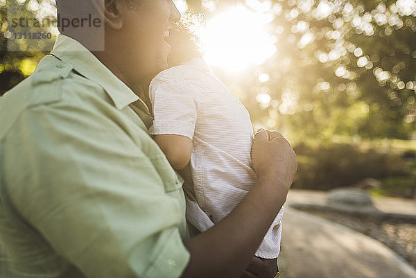 Nahaufnahme eines glücklichen Vaters  der seinen Sohn im Park umarmt