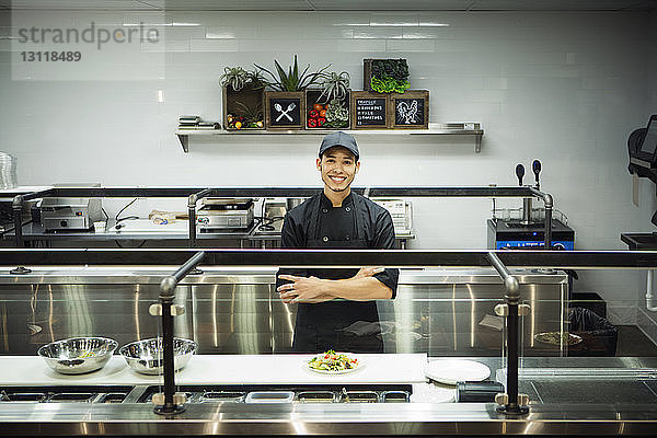 Porträt eines Kochs mit verschränkten Armen im Restaurant stehend