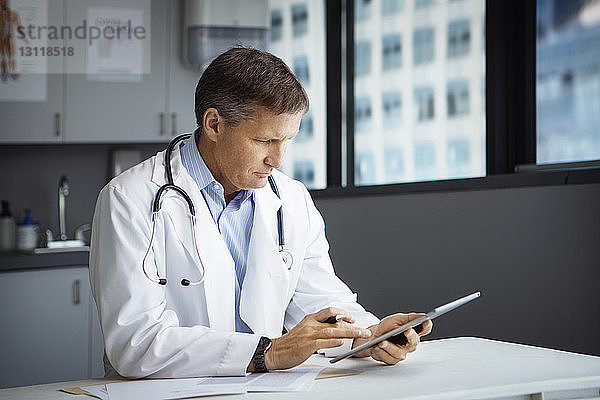 Männlicher Arzt mit Tablet-Computer in der Klinik