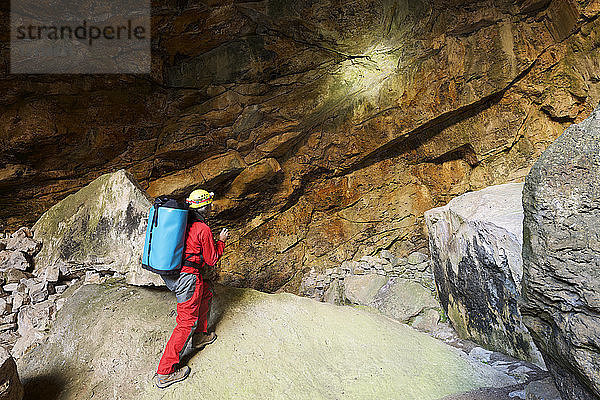Archäologe in voller Länge in Höhle stehend