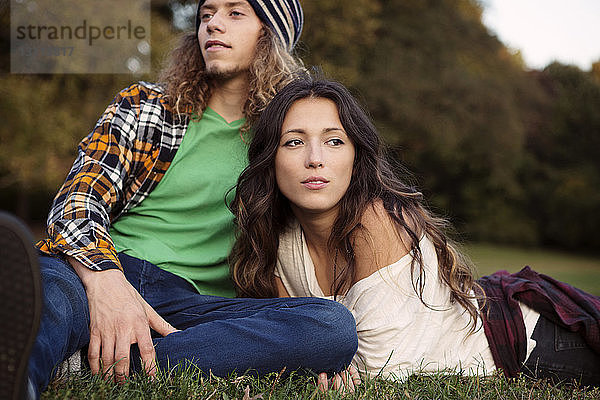 Mann und Frau entspannen sich auf einem Grasfeld