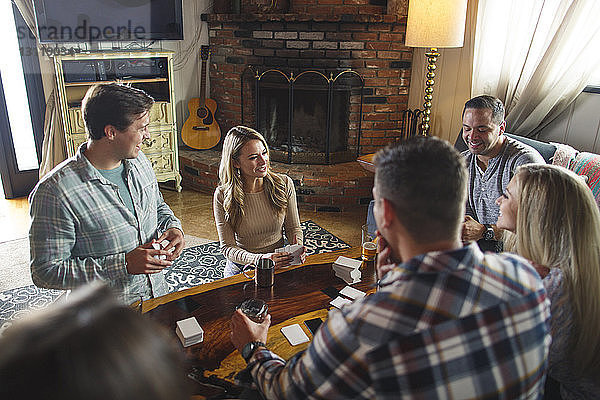 Glückliche Freunde genießen das Kartenspiel beim geselligen Beisammensein zu Hause
