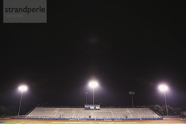 Beleuchtete Scheinwerfer im American-Football-Stadion gegen den Himmel