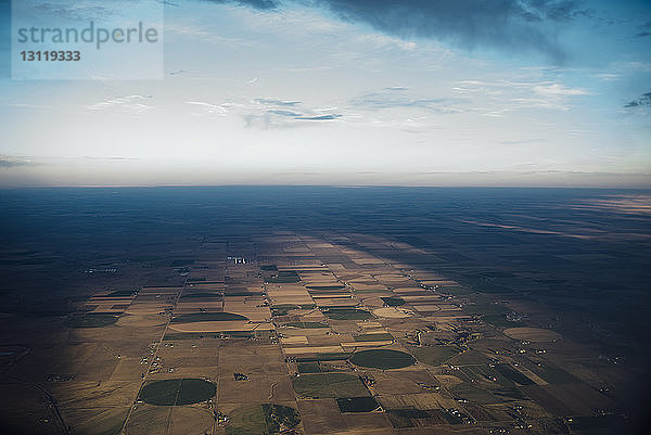 Luftaufnahme einer Patchwork-Landschaft vor bewölktem Himmel