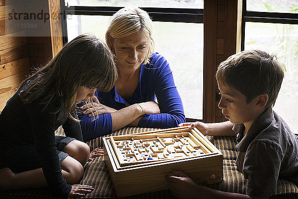 Familie spielt Labyrinthspiel im Haus