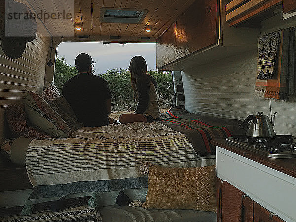 Paar entspannt im Bett im Wohnmobil im Wald