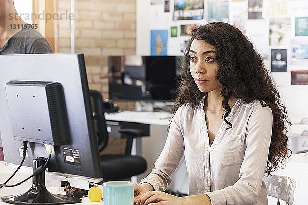 Geschäftsfrau  die im Büro am Desktop-Computer arbeitet
