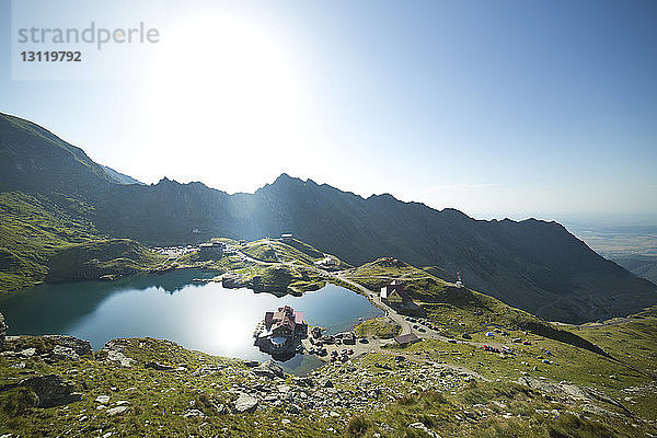 Hochwinkelansicht des Sees durch Berge gegen klaren Himmel