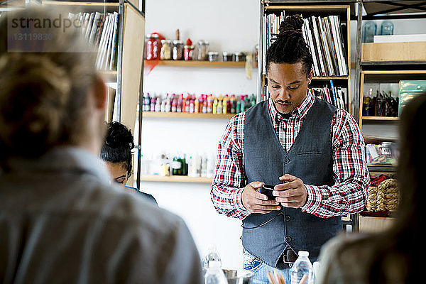 Geschäftsmann benutzt Smartphone während einer Besprechung im Büro