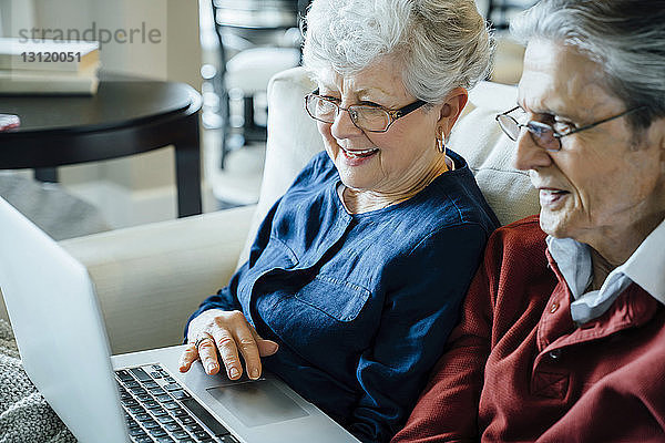 Älteres Ehepaar benutzt Laptop-Computer im Wohnzimmer