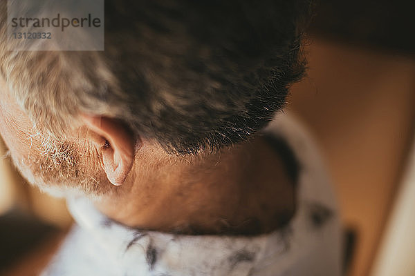 Hochwinkelaufnahme eines Mannes mit Haaren auf dem Rücken beim Friseur