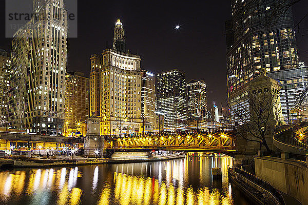 Brücke über den Chicago River gegen beleuchtetes Stadtbild bei Nacht