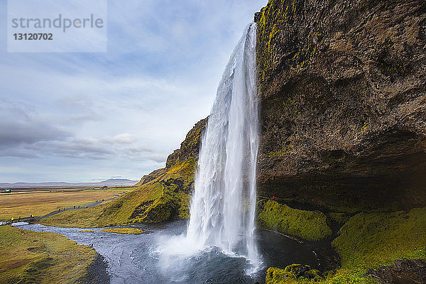 Szenische Ansicht des Wasserfalls vor bewölktem Himmel