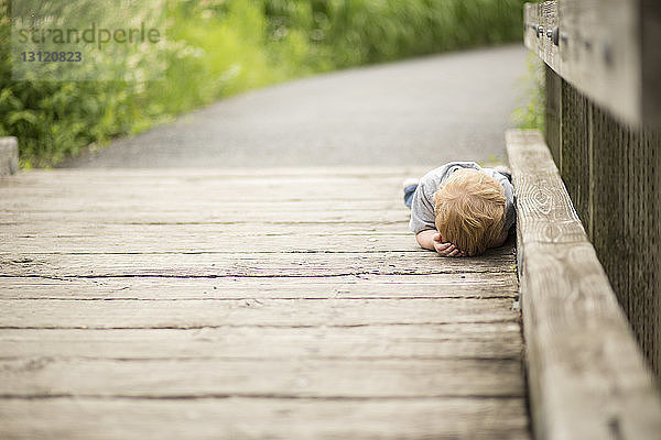 Junge liegt auf der Strandpromenade