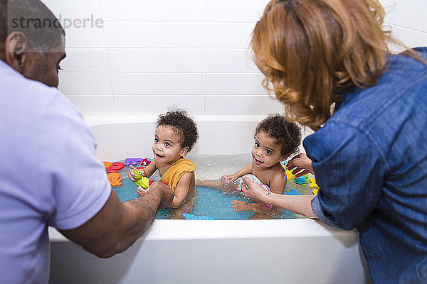 Eltern baden gemeinsam ihre Töchter in der Badewanne