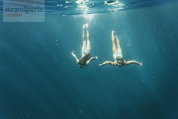 Frauen schwimmen an sonnigen Tagen im Meer