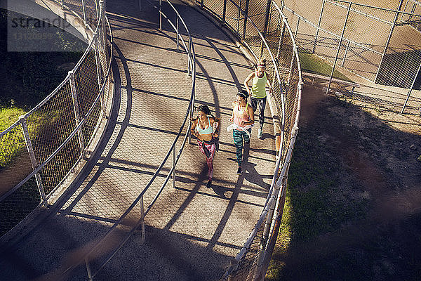 Hochwinkelaufnahme von Athletinnen  die auf der Brücke joggen