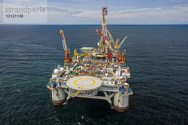 Hochwinkelansicht von Kränen auf einer Ölexplorationsplattform mitten im Meer