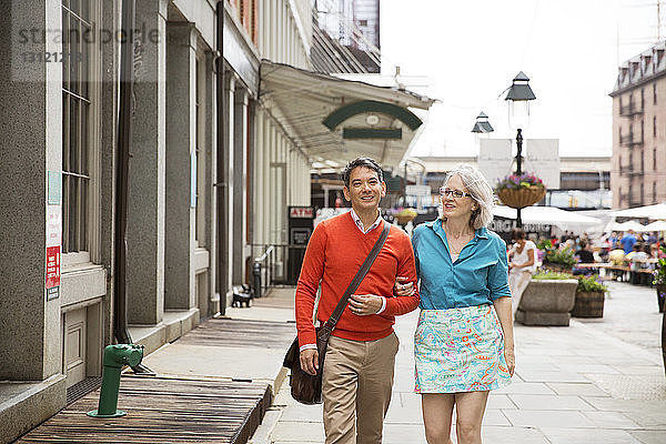 Ein erwachsenes Paar geht in der Stadt auf dem Bürgersteig