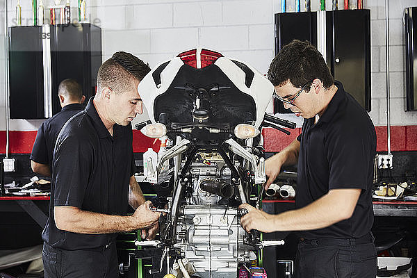 Arbeiter untersuchen Motorrad in Fabrik