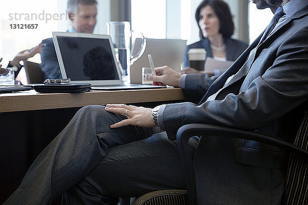 Geschäftsmann sitzt während einer Besprechung im Büro am Schreibtisch