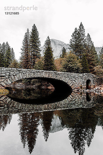 Bogenbrücke über einen ruhigen See im Yosemite-Nationalpark
