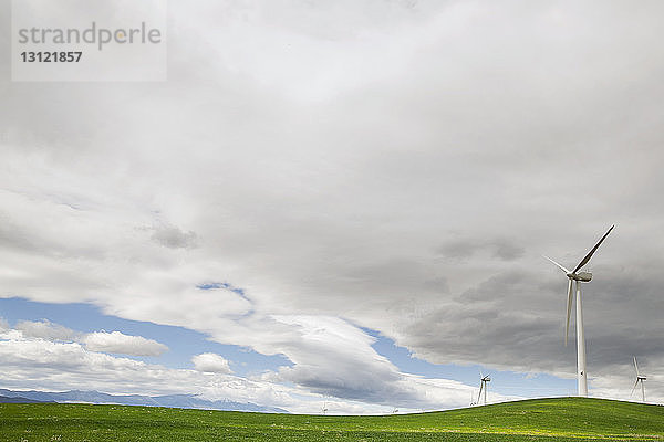 Windturbinen auf dem Feld gegen bewölkten Himmel