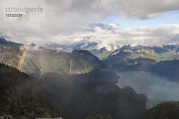 Ruhiger Blick auf den See inmitten der Berge vor bewölktem Himmel