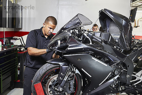 Arbeitnehmer  die in der Fabrik ein Motorrad herstellen