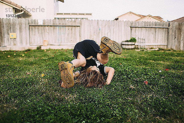 Glückliches Mädchen spielt auf Grasfeld im Hinterhof