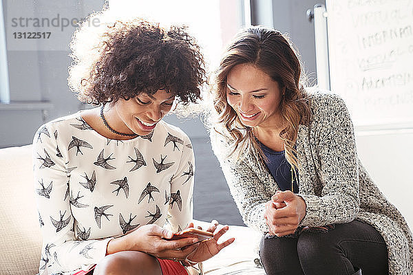 Geschäftsfrauen mit Mobiltelefon im Büro